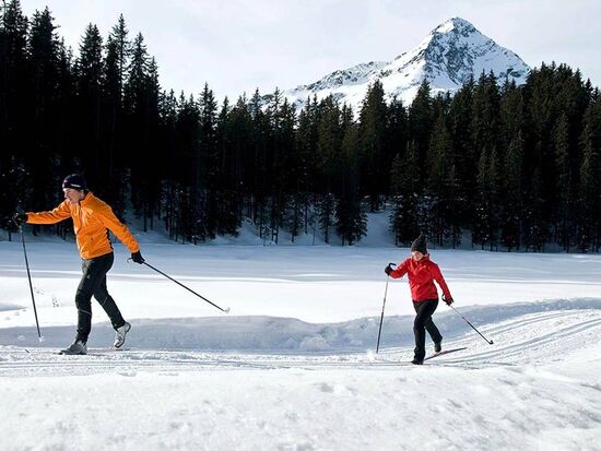 A couple cross-country skiing on a freshly prepared trail